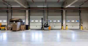 Clean concrete floor in a warehouse near loading docks, showing the result of Facility Upgrades During the Holidays for floor coatings and painting.