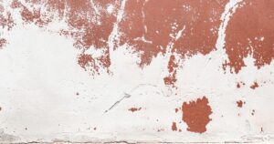 Cracked and peeling exterior wall paint caused by moisture damage showing need to prevent paint failure