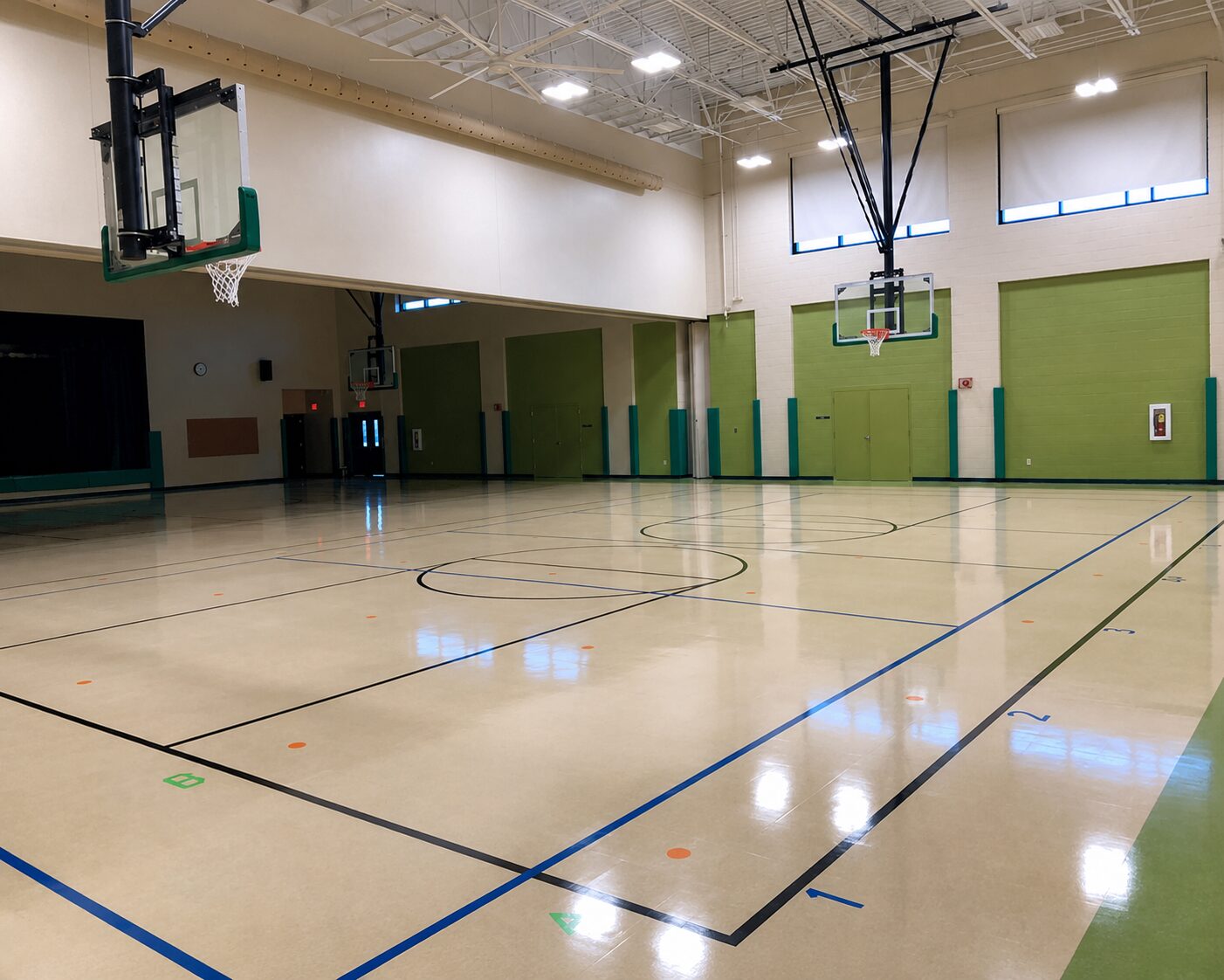 Commercial resinous floor coating in an indoor gymnasium with high-gloss finish and multi-sport line markings installed by Southeast Painters in Chattanooga Tennessee
