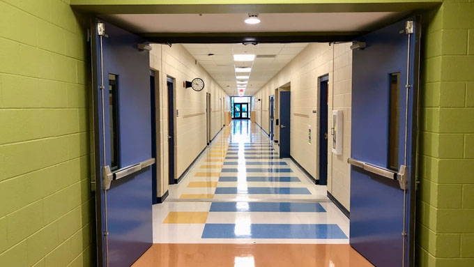 Freshly painted school hallway with green masonry walls coated metal doors white corridor walls and colorful tile flooring at East Brainerd Elementary Chattanooga