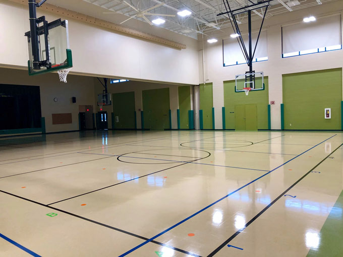 School gymnasium with freshly painted green masonry walls white ceilings basketball hoops and polished court floors at East Brainerd Elementary Chattanooga