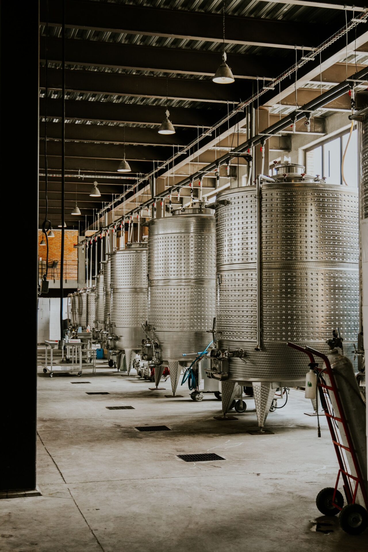 Stainless steel processing tanks and concrete flooring inside a food and beverage production facility requiring specialized industrial coatings