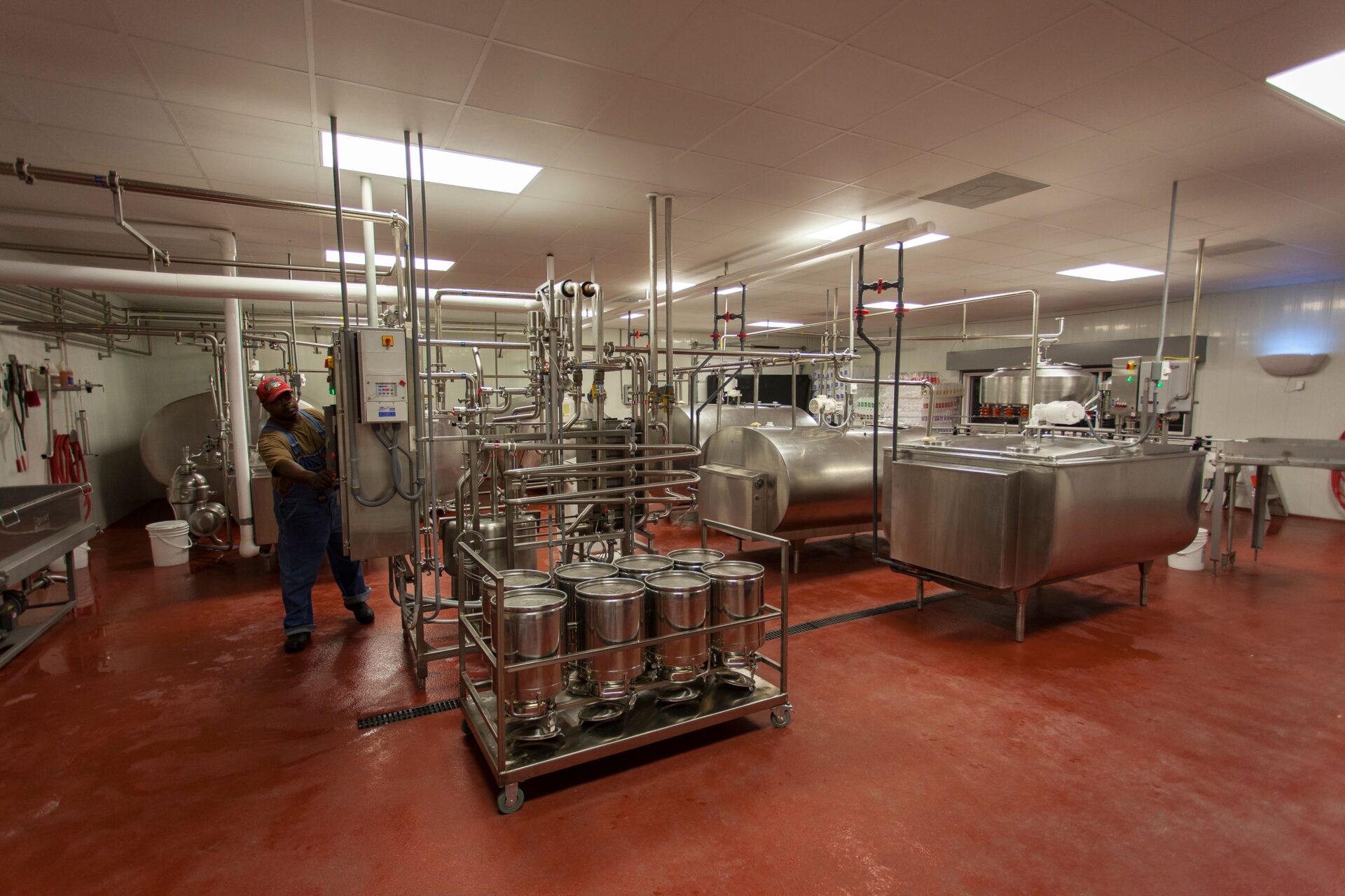 Food processing facility with red resinous floor coating stainless steel equipment and coated white walls and ceiling in a USDA inspected plant